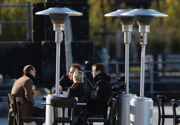 BERLIN - NOVEMBER 17: Patio heaters stand at a outside cafe as people's enjoy the sun on November 17, 2008 in Berlin, Germany. Five Berlin districts have agreed to ban patio heaters at outdoor restaurants in the new year because the heat lamps guzzle energy and pollute the air. The controversial heaters, popularly known in Germany as Heizpilze, or heat mushrooms, because they are shaped like the fungus, have again been popping up in their thousands on outdoor terraces and sidewalks as colder weather takes hold. (Photo by Andreas Rentz/Getty Images)