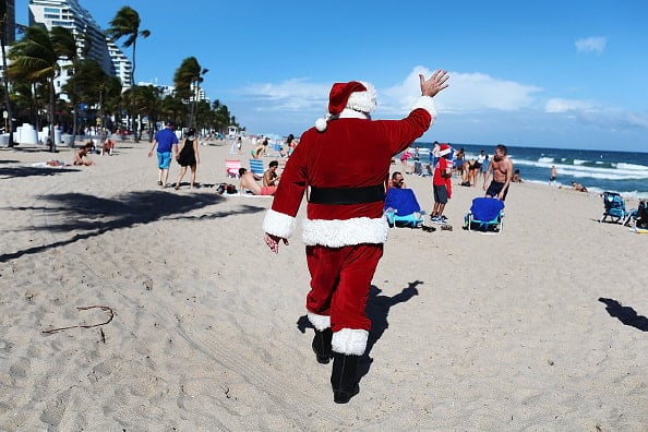 Santa Passes Out Presents On The Beach In Fort Lauderdale, Florida